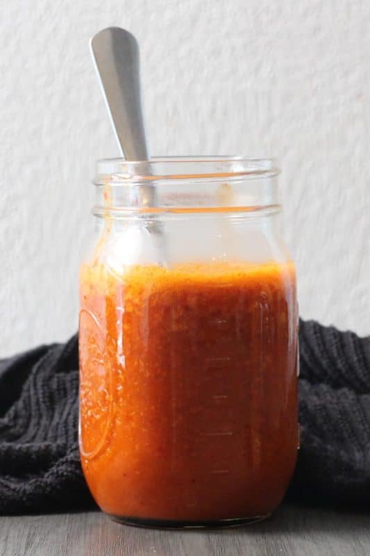 jar of fried pepper hot sauce with a spoon in it
