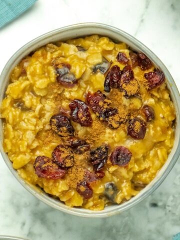 bowl of pumpkin oatmeal with cranberries and pumpkin spice