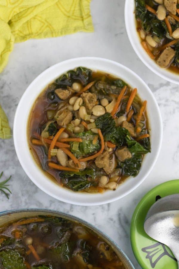 bowl of kale and bean soup on a table
