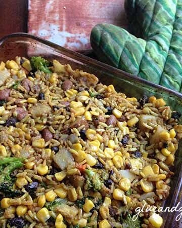 A casserole dish of beans and rice with corn and broccoli