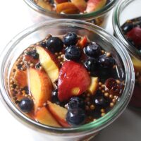 jars of pickled peaches and blueberries  on a white table
