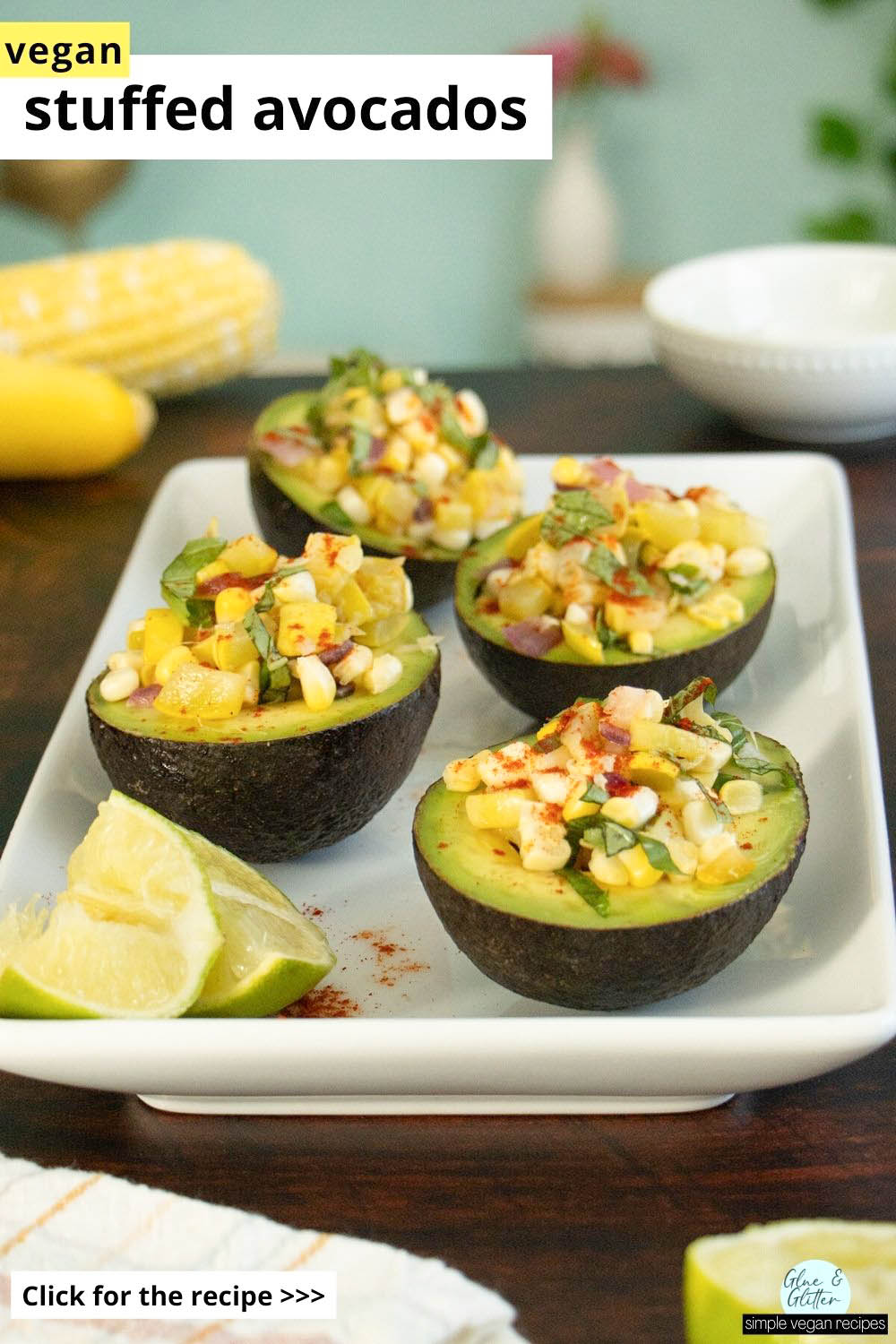 stuffed avocados with corn and summer squash on a wooden table, text overlay