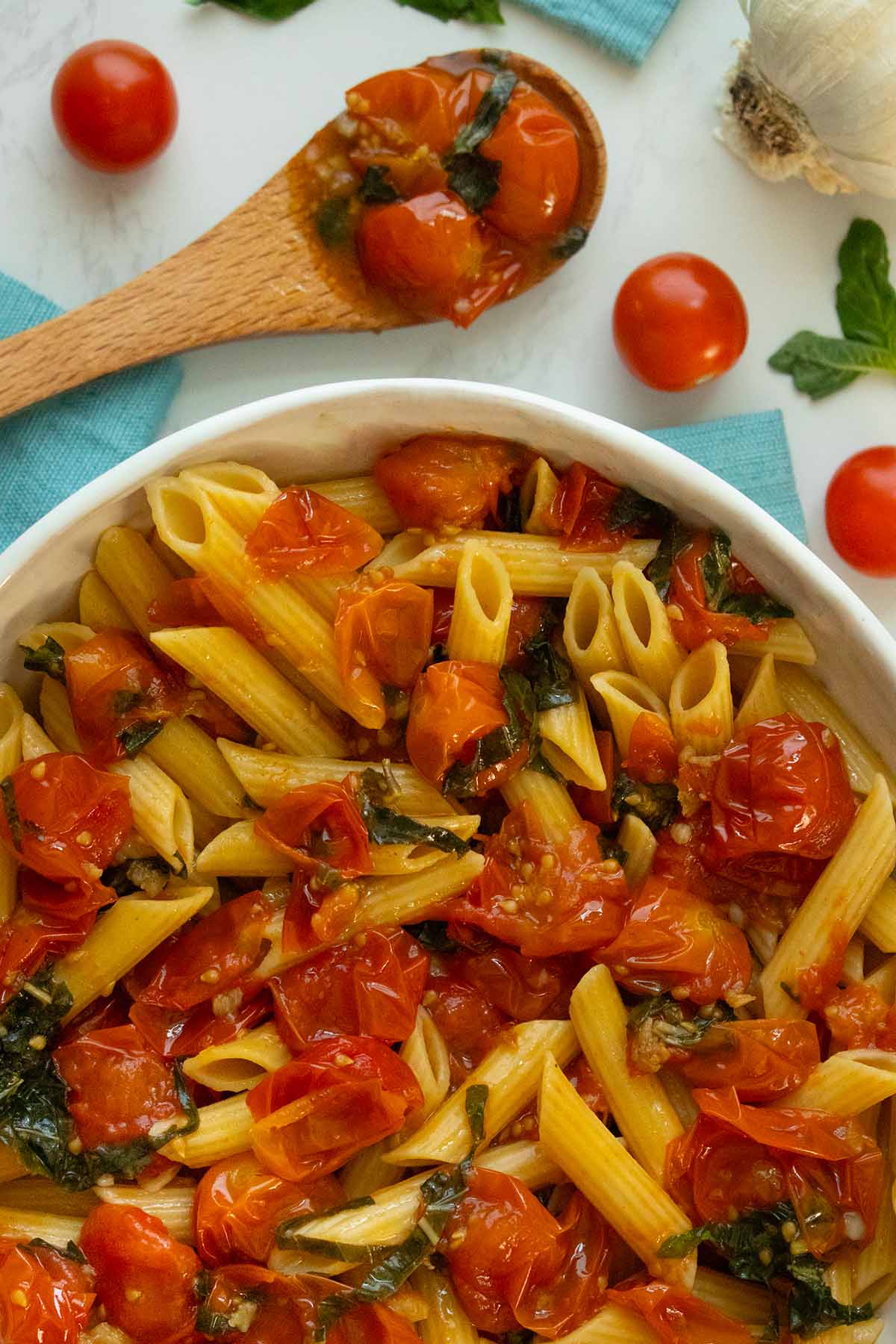 bowl of pasta with roasted cherry tomatoes, basil, and garlic
