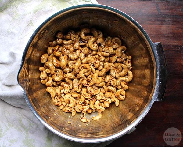 bowl of raw cashews tossed with sauce, ready to roast