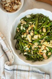 roasted frozen green beans in a serving dish topped with almonds