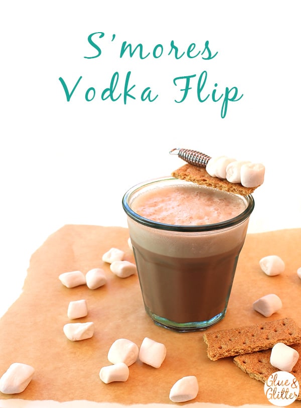 a s\'mores cocktail in a glass with graham cracker and marshmallow garnish, text overlay