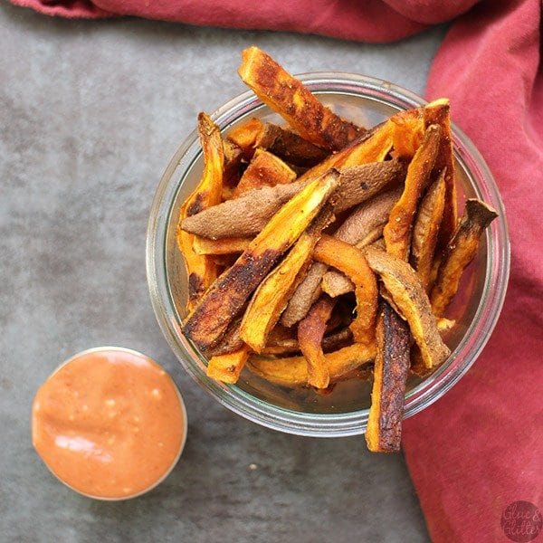 overhead photo of a serving container of sweet potato fries next to creamy dipping sauce