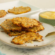stack of vegan latkes on a plate with a bite taken out of one, so you can see inside