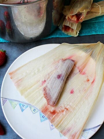 unwrapped strawberry tamale still on the corn husk next to the Instant Pot's inner pot