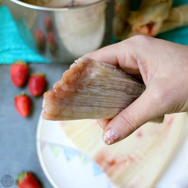 hand holding a cooked strawberry tamale