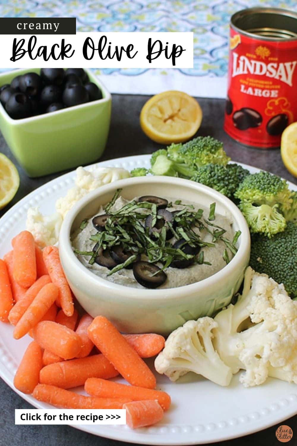 black olive dip in a serving bowl surrounded by veggies