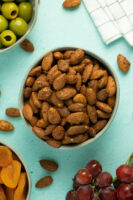 bowl of air fryer almonds as part of a party spread with olives and dried apricots