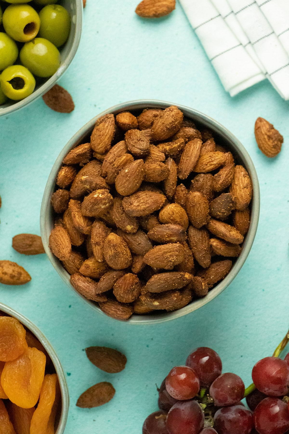 bowl of air fryer roasted almonds as part of a party spread with olives and dried apricots