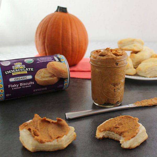biscuits spread with pumpkin almond butter, the jar and knife in the background