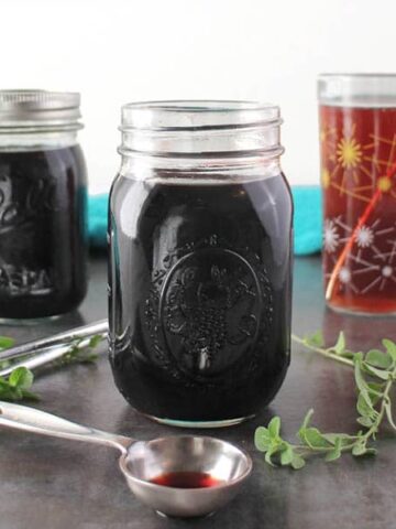 jar of elderberry syrup next to a tablespoon