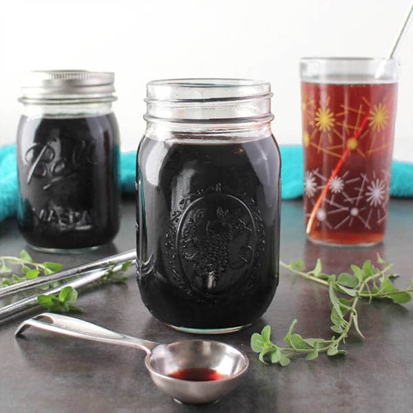 jar of elderberry syrup next to a tablespoon