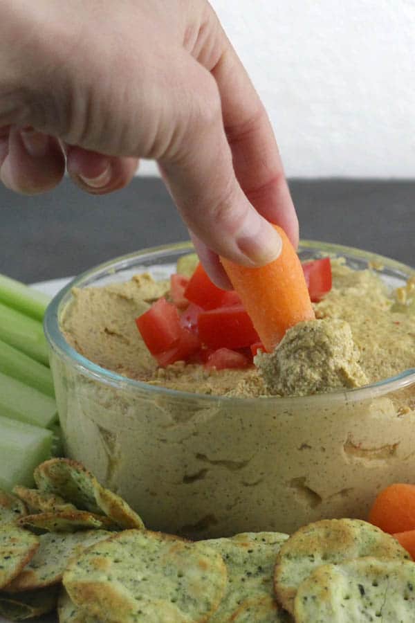 dipping a carrot into sunflower seed dip