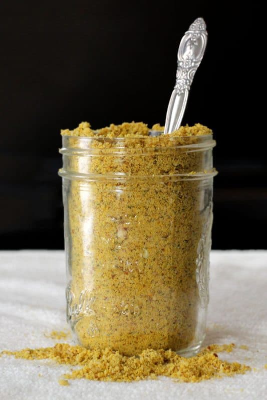 jar of vegan Parmesan cheese fairy dust with a spoon in it