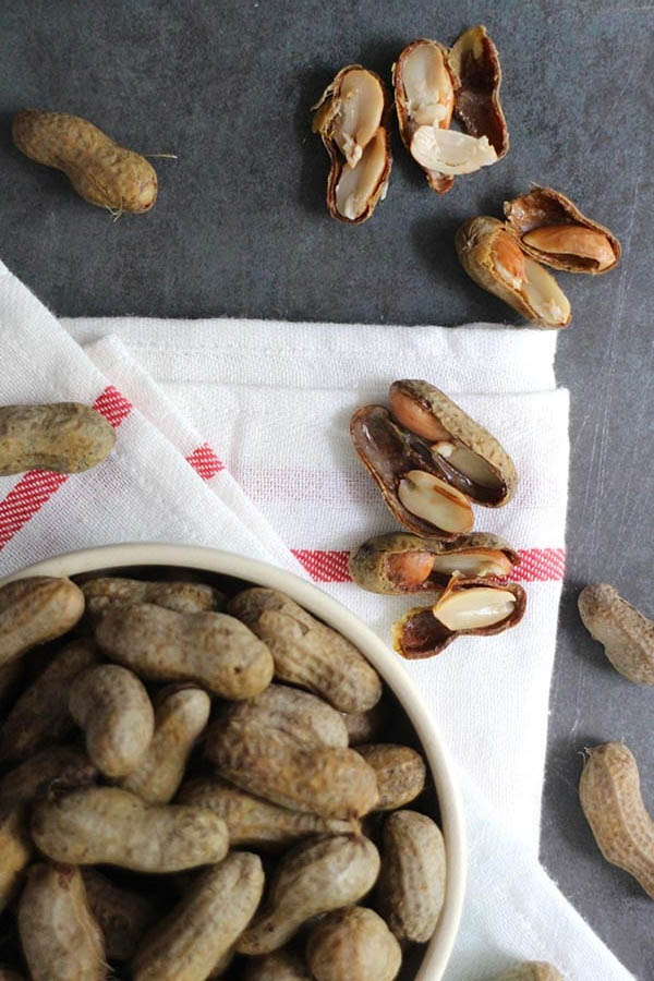 Pressure Cooker Boiled Peanuts in a bowl with boiled peanuts scattered on the table