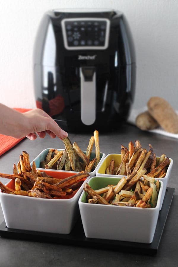 colorful serving dish of french fries with air fryer in the background