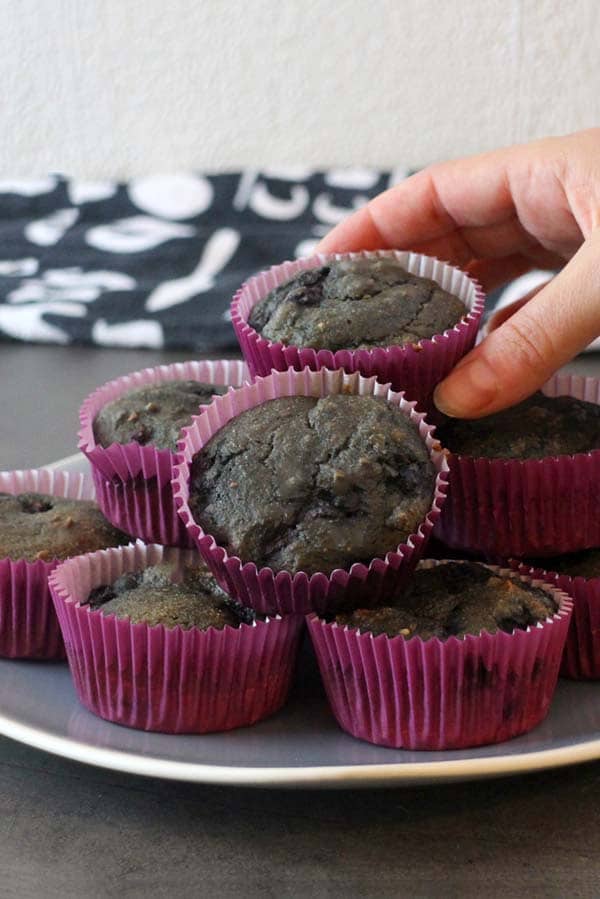 plate of vegan Halloween muffins with a hand picking one of them up