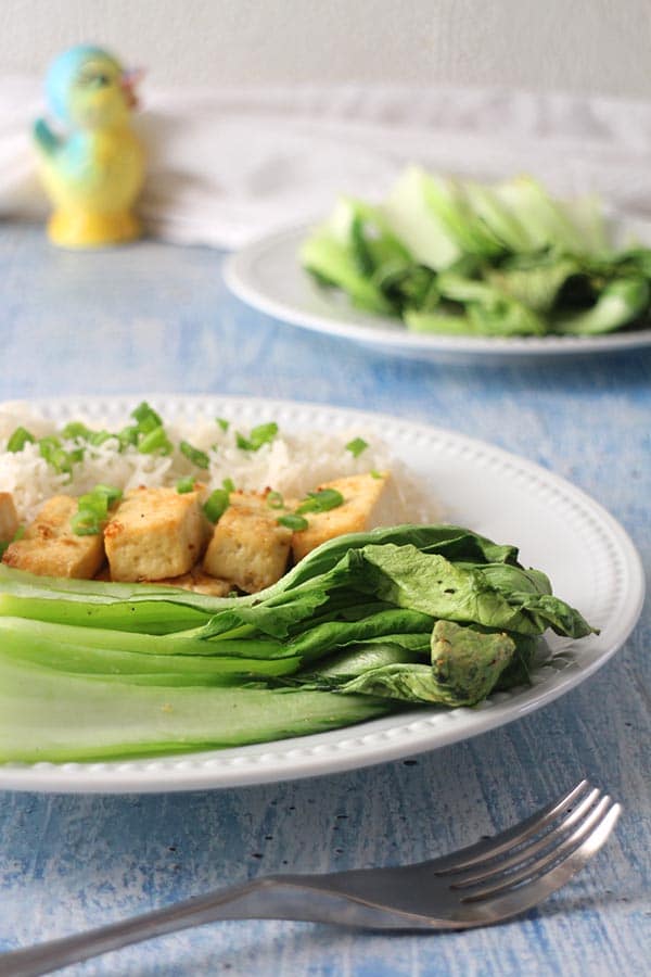 close-up of air fryer baby bok choy on a white plate with tofu and rice