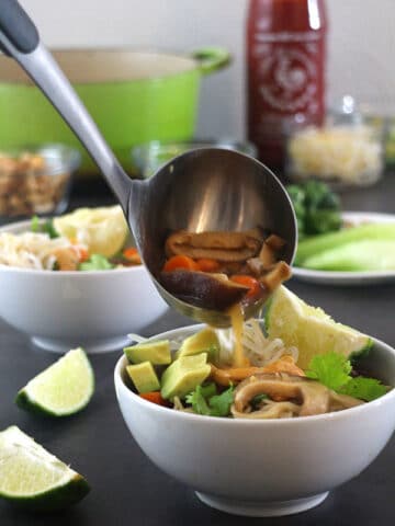 ladling vegan ramen into a bowl