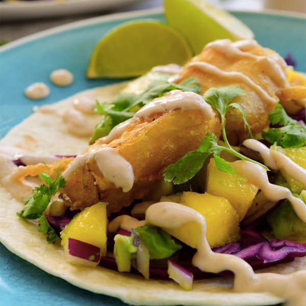 photo of vegan fish tacos with creamy sauce and fruit salsa