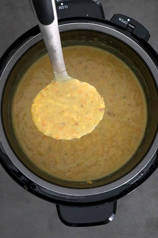 Ladle serving broccoli cheese soup from the pressure cooker