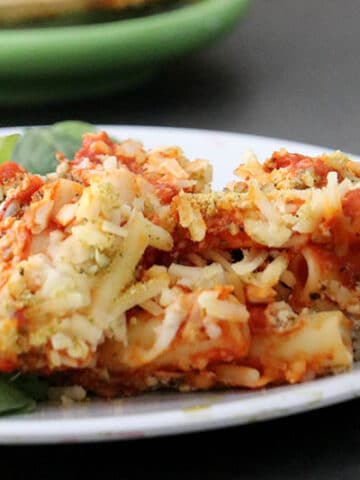 close-up of vegan baked ziti on a plate with green salad