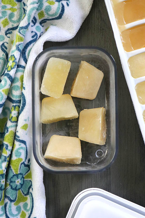 frozen chickpea and white bean aquafaba cubes in an ice tray and in a freezer-safe container