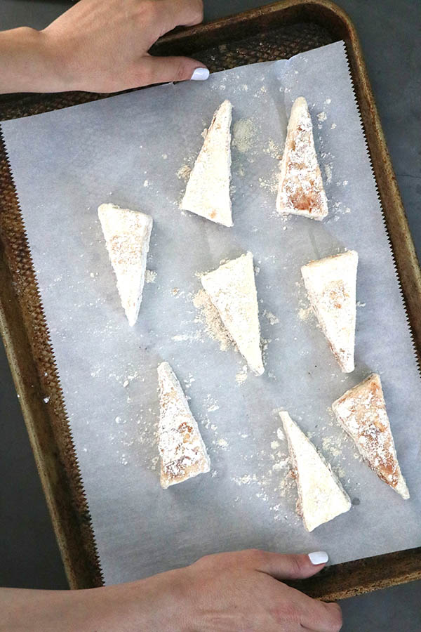 breaded tofu triangles arranged on a lined baking sheet