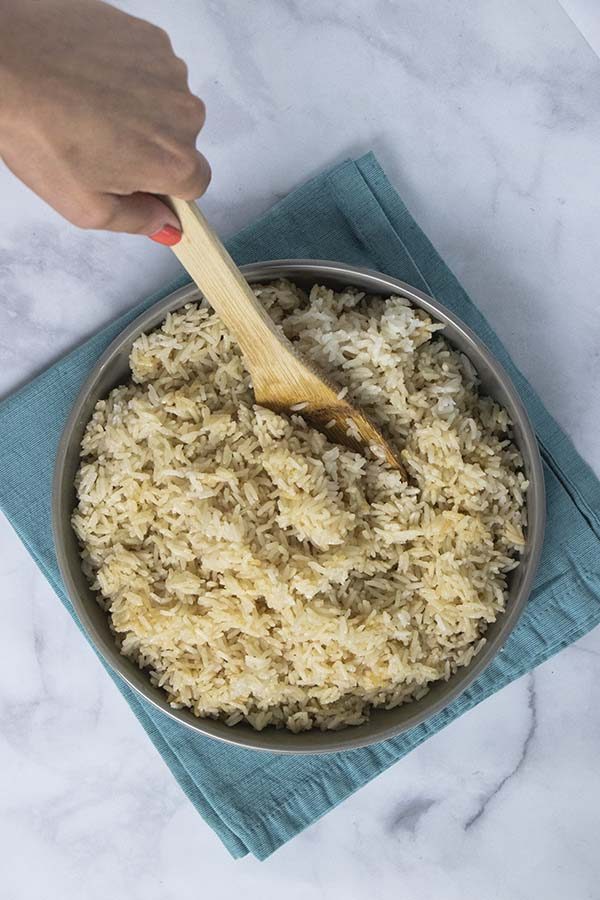 serving spoon dipping into a bowl of Instant Pot coconut rice