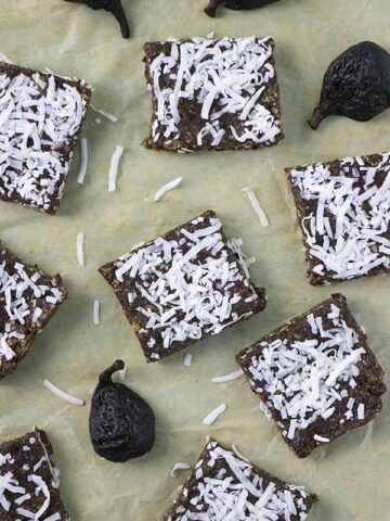 vegan fig bars topped with shredded coconut on parchment paper