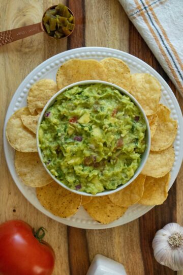 bowl of pickled jalapeño guacamole surrounded by chips