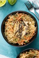 kelp noodle salad with carrots and green onions topped with shiitake mushrooms in a bowl