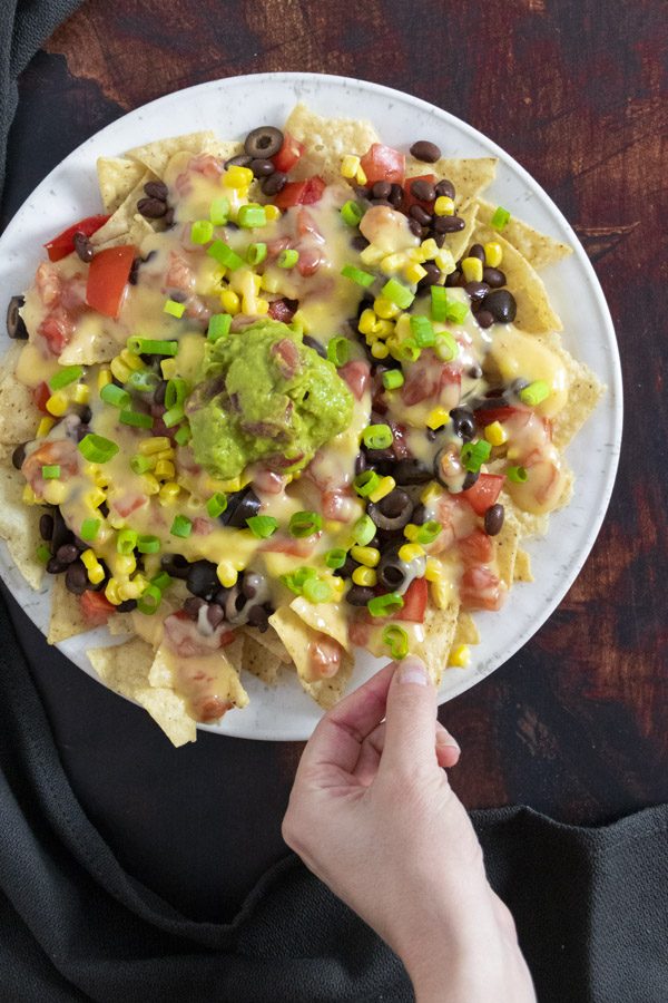 plate of vegan nachos made with vegan queso