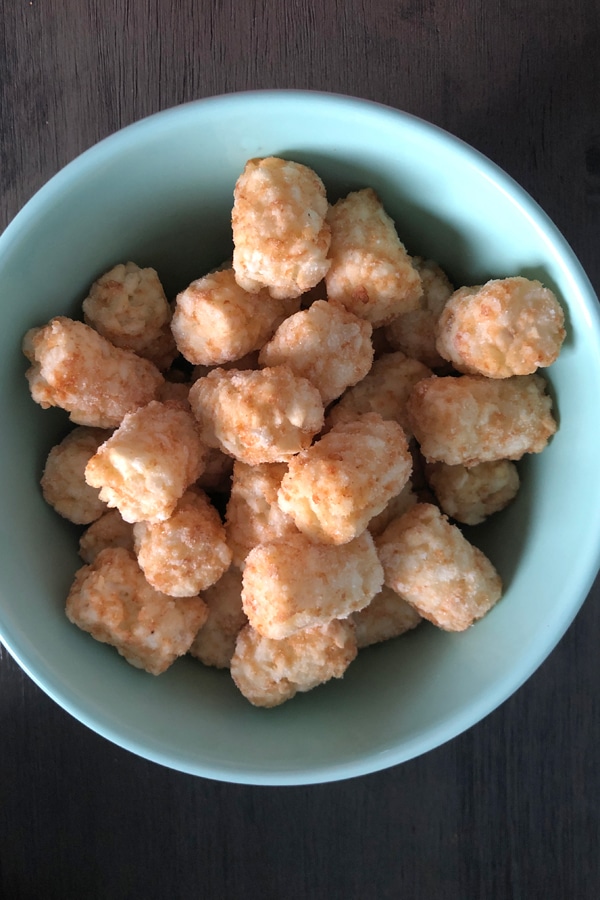 frozen tater tots in a blue bowl