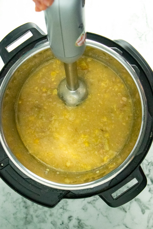 blending the corn chowder in the Instant Pot with an immersion blender