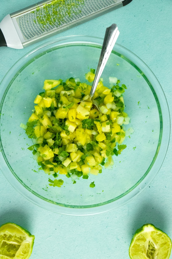 glass bowl of pineapple salsa ingredients mixed and ready to serve or store