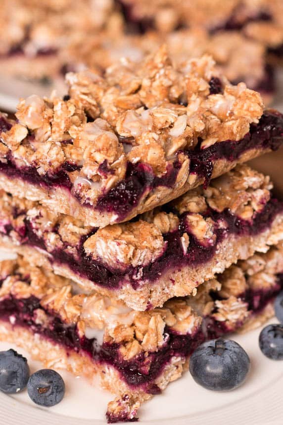 close-up of a stack of blueberry snack bars with fresh blueberries on the table
