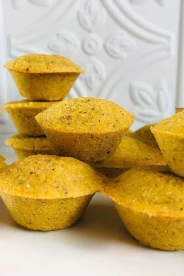 cornbread muffins piled onto a white tabletop