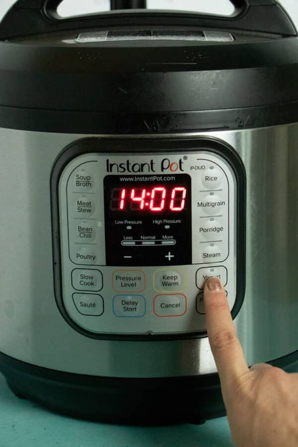 photo of finger pressing the yogurt button on the Instant Pot. The timer reads 14:00