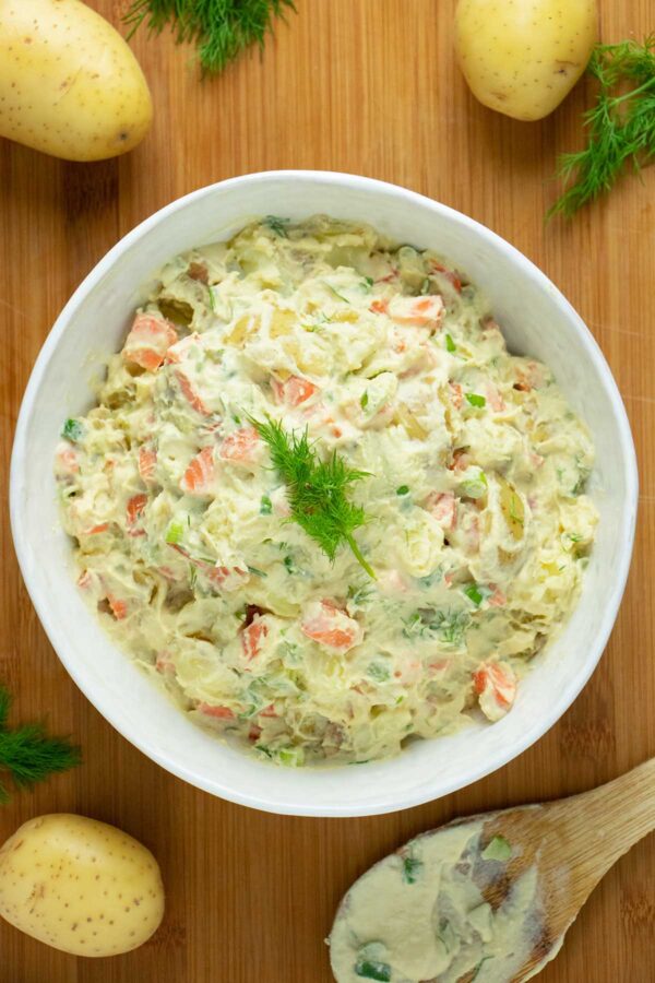 serving bowl of creamy vegan dill potato salad on a wooden table