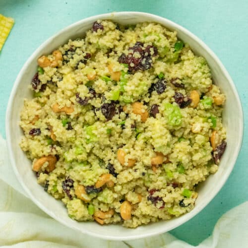 overhead photo of quinoa salad with cranberries, avocado, cashews, and green onion in a white bowl