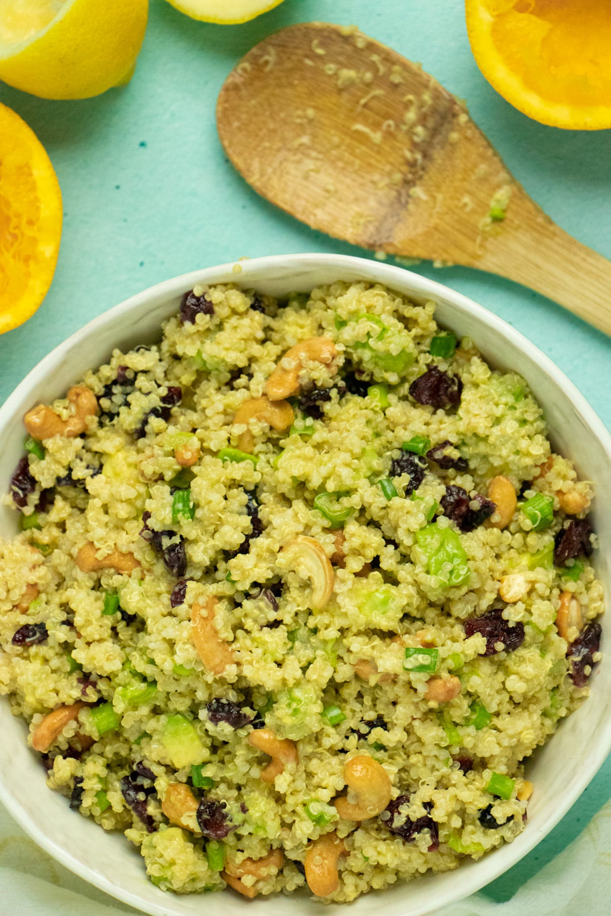 close-up of a serving bowl of quinoa salad with cranberries, avocado, green onion, and cashews