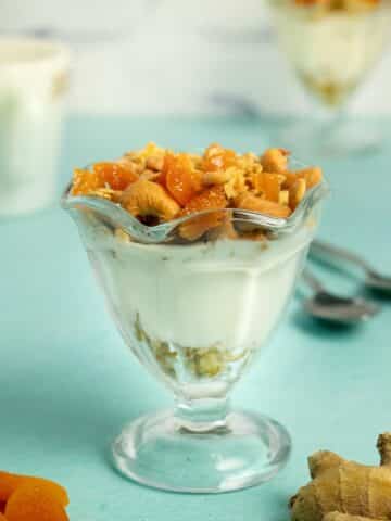 ginger apricot granola parfait in a parfait glass with non-dairy yogurt