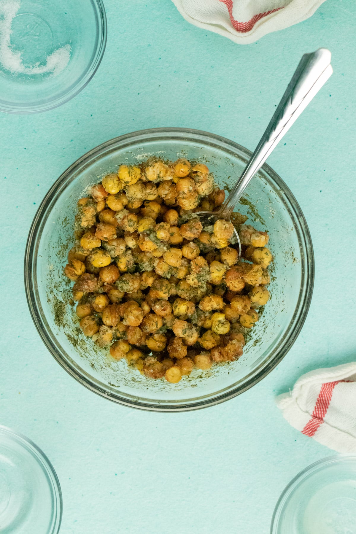 mixing bowl of cooked chickpeas tossed with ranch seasoning with a large spoon