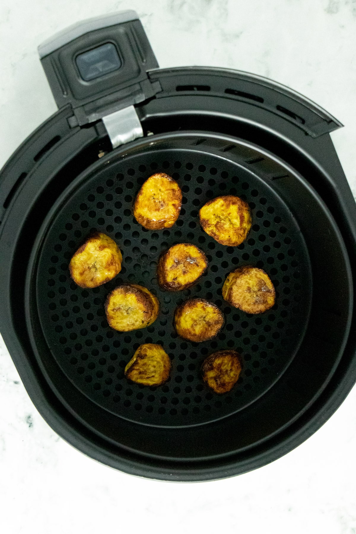 cooked plantains in an air fryer basket