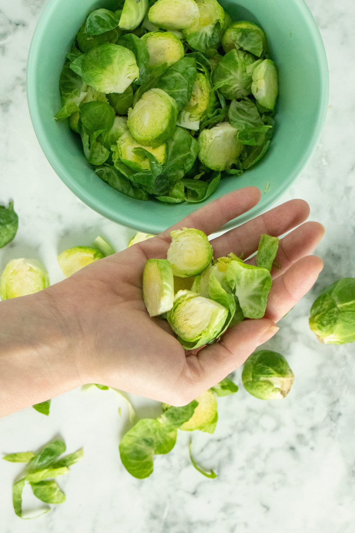 bowl of sliced Brussels sprouts on a marble tabletop